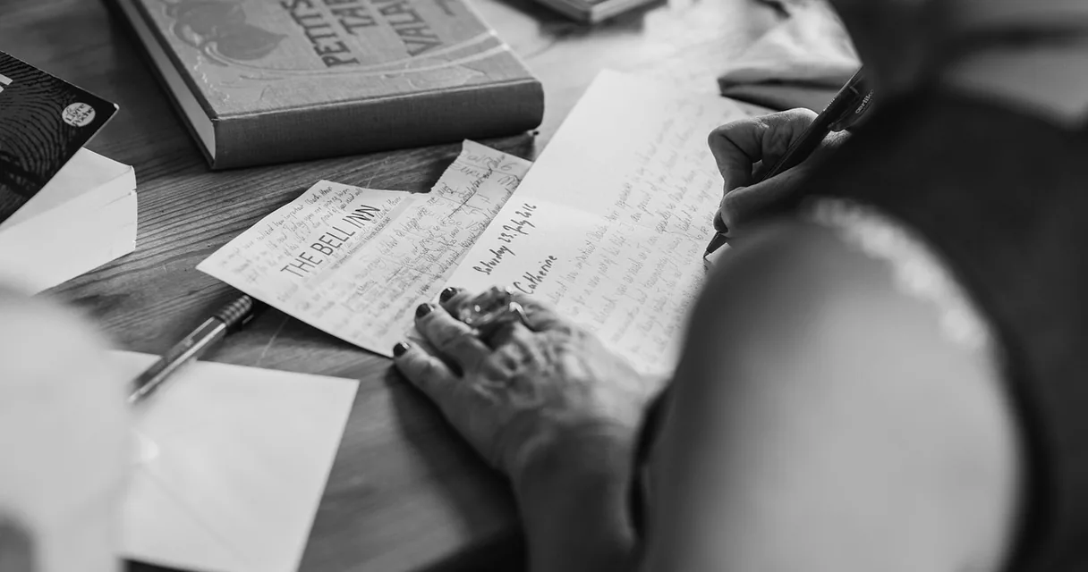 Mãos escrevendo uma carta à mão em preto e branco, modelos de carta para dependente químico
