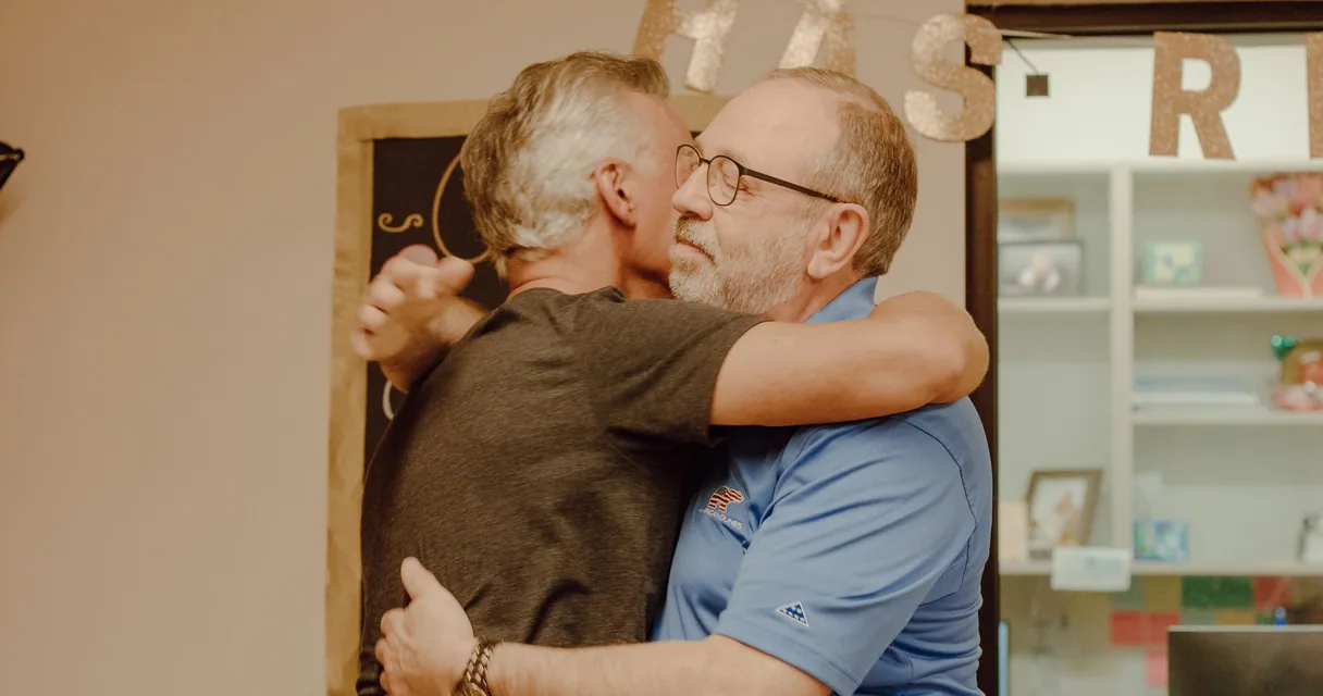 Dois homens se abraçando em um gesto de apoio e afeto, o dependente químico tem sentimentos