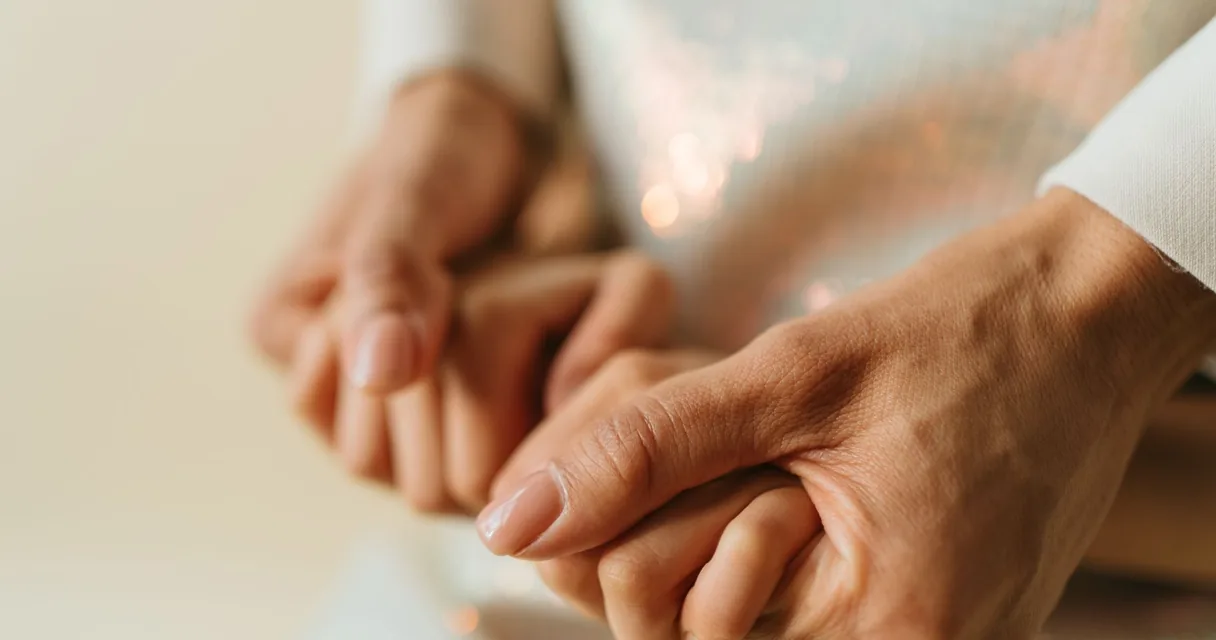 Mãos de mãe e filho entrelaçadas em close, palavras de mãe para filho que usa droga