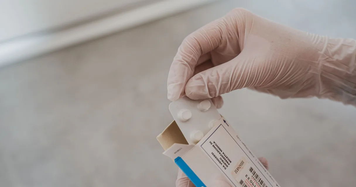 Comprimidos e cartelas de remédio sobre a mesa de um consultório, medicamentos usados para parar de beber